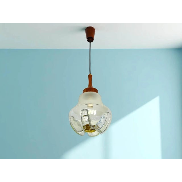 This beautiful hanging light in the style of Mazzega was made in the 1960s. The support is in wood, and the shade is in...