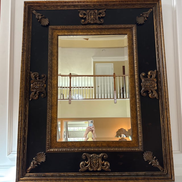 Black and gold fireplace mantle or standing wall mirror.
