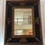 Black and gold fireplace mantle or standing wall mirror.