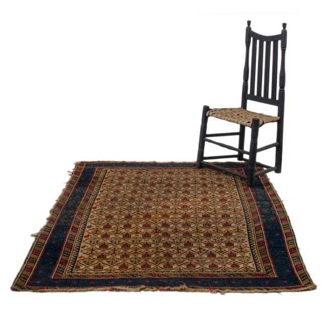 An antique Daghestan rug, circa 1900. Repeating rows of red tulips and flowers on ivory ground. Blue and black lattice...
