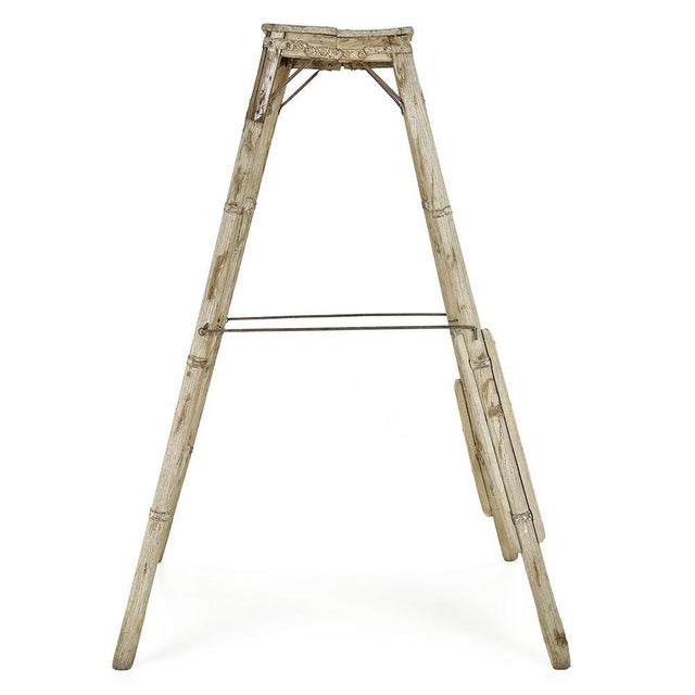 Slender, worn by time and reinforced with riveted fittings, this antique stepladder is a testament to robust craftsmanship...