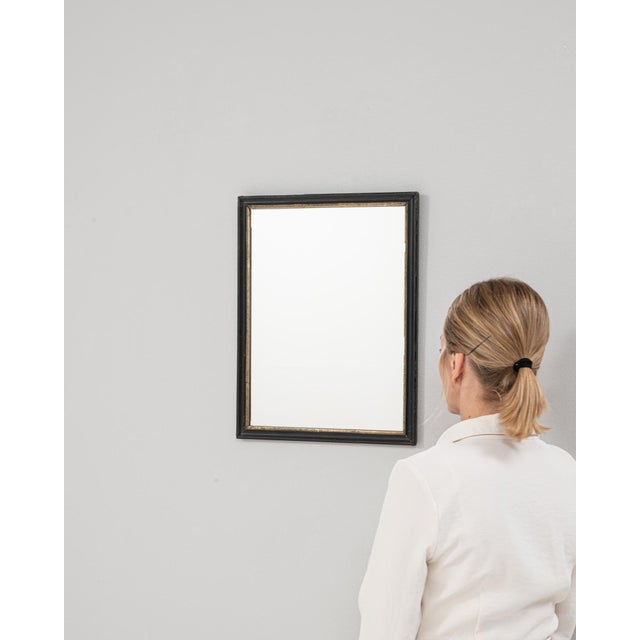 This 1880s French mirror features a simple, refined wooden frame finished in a softly worn black patina that highlights...