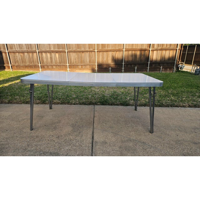 Gorgeous original 1950s formica and chrome extension dining table. Gray speckled formica top with classic chrome banding...