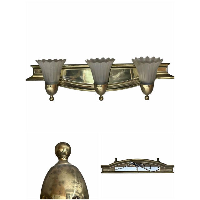 A elegant vintage 3-light wall sconce vanity light fixture. Features a polished brass frame paired with three frosted...