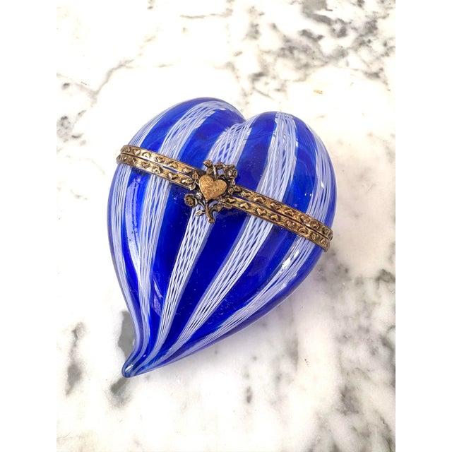 A metal braced heart shaped Venetian glass trinket box, Murano, Italy, circa 1970s. A swirled cobalt blue and white glass...