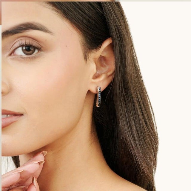 An elegant pair of blue sapphire earrings featuring 1.88 carats of gemstones, crafted in 925 sterling silver and designed...