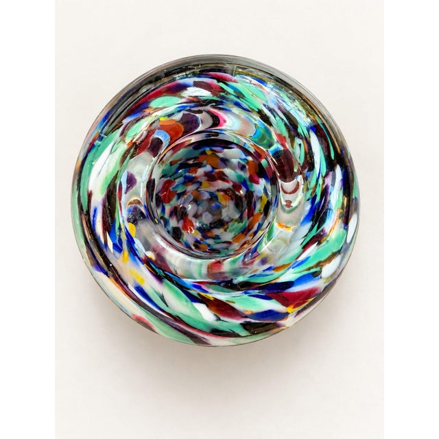 This striking 1990s American studio art glass vase features a vibrant, multi-colored frit swirl pattern encased in heavy,...