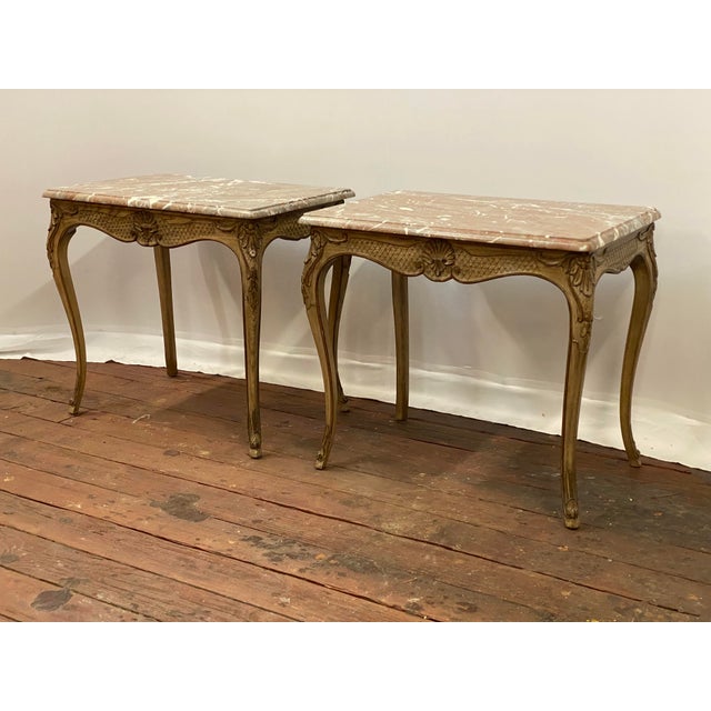A nicely carved pair of Louis XV style oak and marble top end tables. Circa 1970-1980. Each solid oak frame has finely...