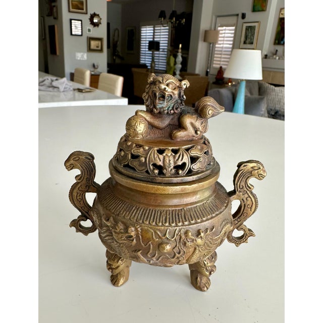 Well crafted Chinese brass or bronze incense burner with three legs, features intricate dragon-shaped handles on the sides...