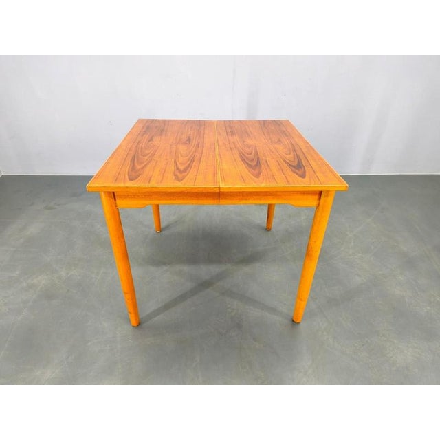 Elegant mid-century modern dining table from Denmark, dating to the 1960s. Crafted from solid teak and teak veneer, this...