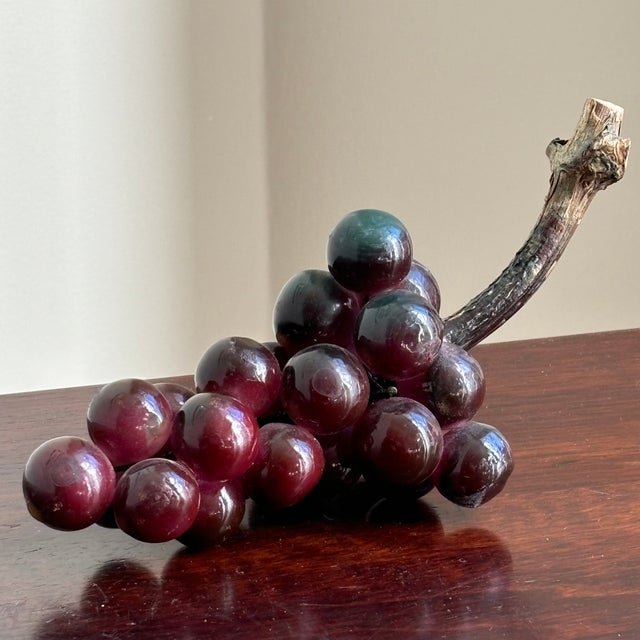 A small, but very lovely mid-20th century lucite grape cluster with natural wood stem. This cluster is rich, warm purple...
