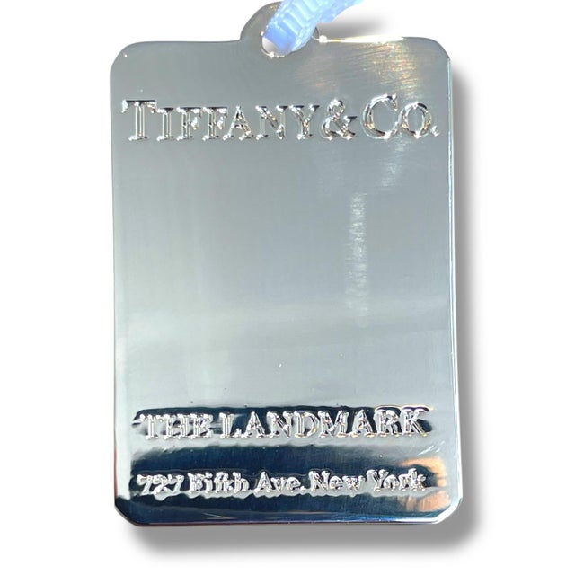 Elevate your holiday decor with the limited edition Tiffany & Co. Silver toned Tag Charm, a stunning Christmas ornament...