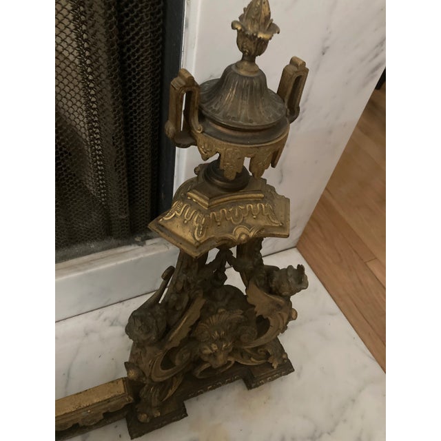 3 pieces 19th Century Bronze Chenets , Two Andirons mounted on a urn with figurine and a lion head and a central fender...