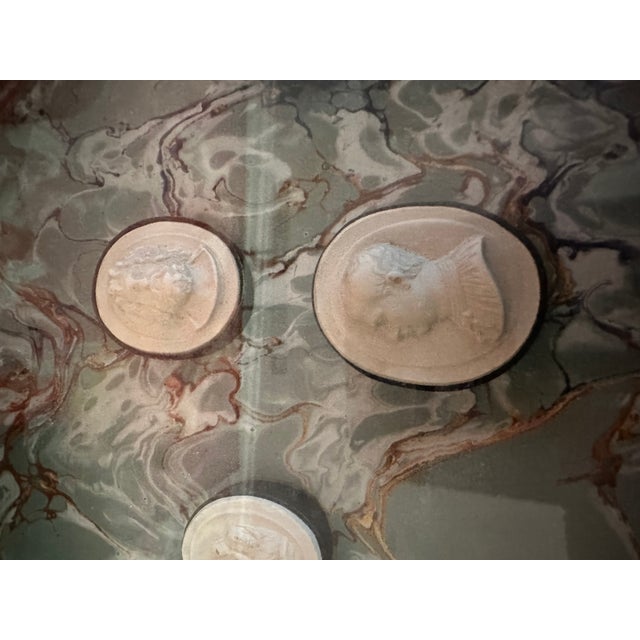 A very smartly framed set of intaglios 8 individual plaques banded in black with neoclassical figures the frame is black...