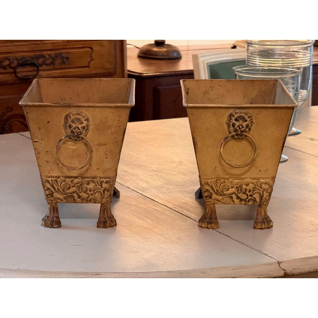 Pair of tapered tole planters in a mellow yellow finish, with lion mask ring handles, an embossed foliate band at the base...