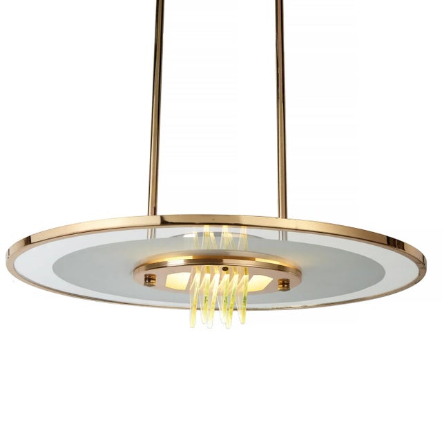 Mid-century pendant light with glass disc saucer with glass fins filtering the bulb. Rigid poles attach to the ceiling...