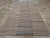 This mid-20th century Persian flatweave kilim rug, measuring 6' 10" x 12' 10", features a beautifully balanced striped...