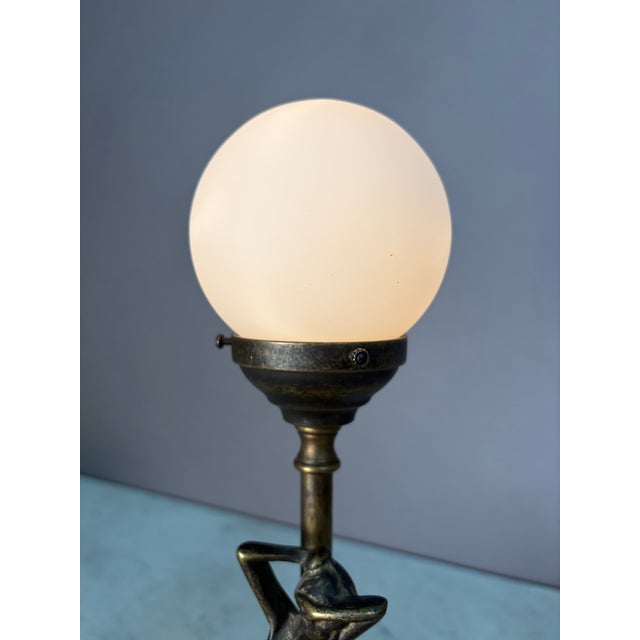 Antique bronze globe lamp with a statuesque woman figure on the stem. Corded electric. Comes with white glass globe and...