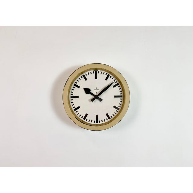 This wall clock was produced by Siemens in Germany during the 1950s. It features a beige metal frame, a metal dial and a...
