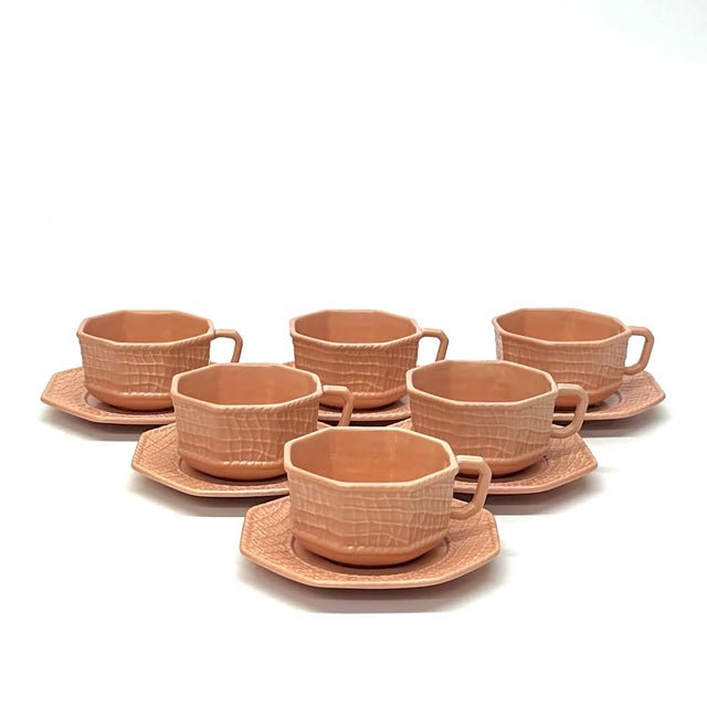 Blush cups and saucers, group of 6. This group of blush-pink ceramic cups and saucers are octagonal with a soft-matte net...
