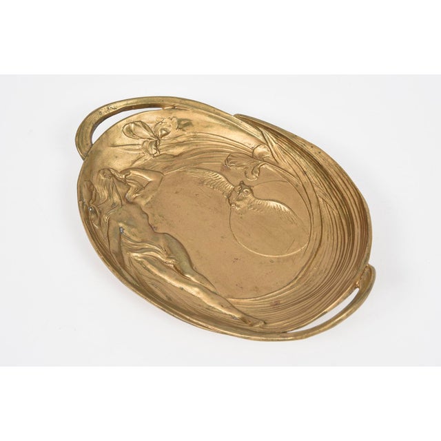 Art Nouveau dore bronze tray features a figural motif in semi-relief, depicting a sensuous maiden figure surrounded by...