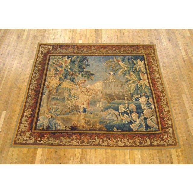 A French Aubusson genre tapestry panel from the 18th century, envisioning a hunter walking with a rifle resting on his...
