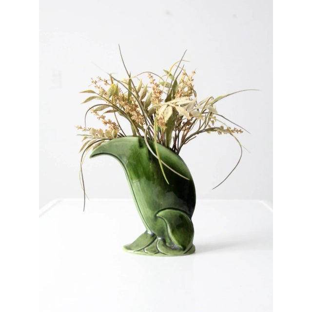 Vintage decorative ceramic vase, circa 1940s, featuring a rich dark green glaze and a flowing raised foliage motif. The...