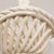 A beautiful white ceramic basket. This piece features woven ceramic braids surrounding a small basket with a handle....