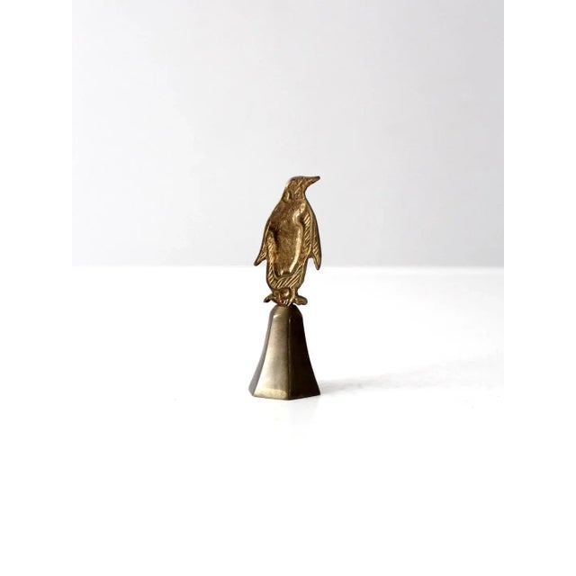 This is a vintage brass penguin atop a stand. Once a bell, it makes a lovely desk or shelf accent and could be used to...