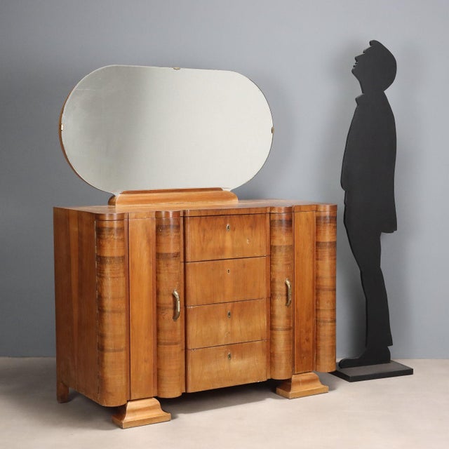 Dresser with mirror, side doors, hinged doors, and drawers with exposed center section. Made of walnut veneer. In fair...
