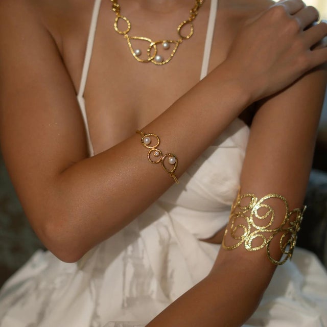 illuminate your style with the timeless elegance of the Handmade Radiance Pearl & Gold Adjustable Bracelet. Crafted from...