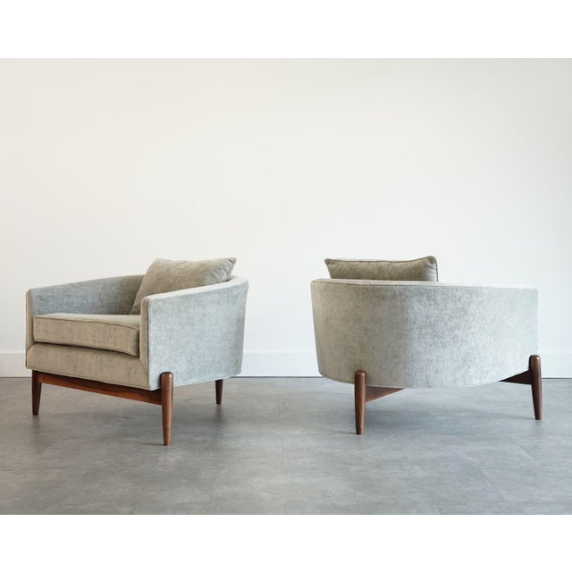 A refined pair of 1950s tripod barrelback lounge chairs in the style of Jens Risom, showcasing clean mid-century lines and...