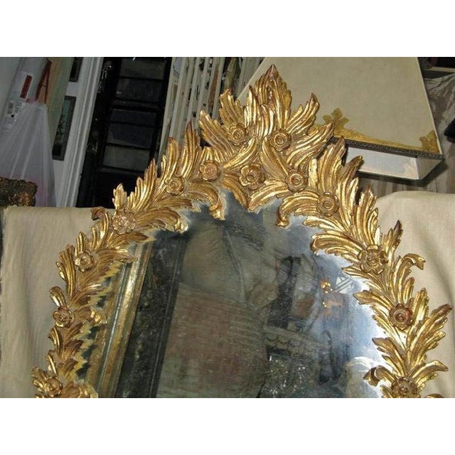 Exquisite in every way, this gilt wood mirror from the 1930's is made from carved acanthus leaves and tiny flowers....
