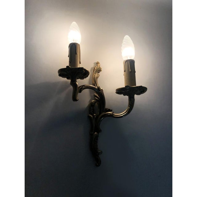 Antique double-light bronze wall sconce with acanthus leaf design. 1950s Bronze wall sconce, the sconce topped with two...