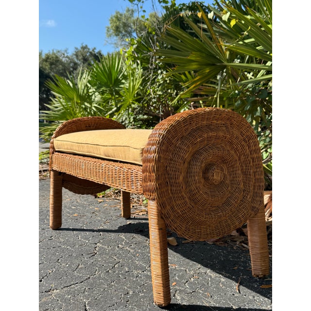 Charming vintage wicker bench featuring a beautifully sculptural silhouette with rounded barrel-style arms and backrests...