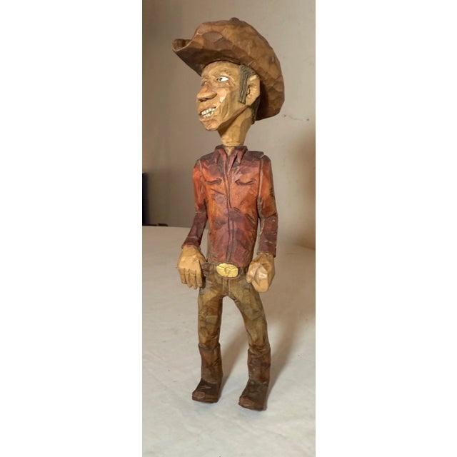 This exquisite hand carved wood sculpture of a cowboy is a unique piece of folk art created by artist R.E.A.. The...
