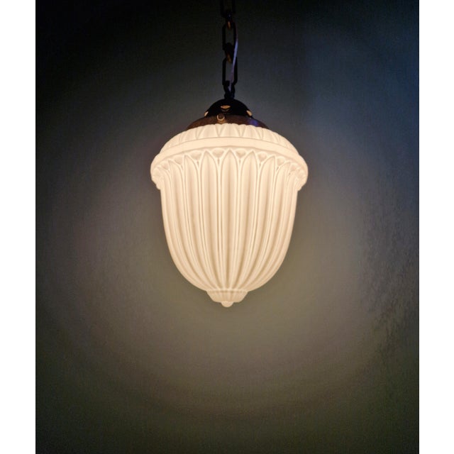 Art Deco pendant light in pressed molded white opaline glass with a copper-plated metal frame, 1920s-30s. The pendant...