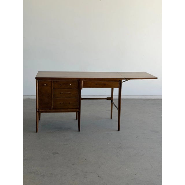 W46.5 Extended W64.25 D22 H29.25 Fully refinished mid century walnut desk, with original hardware. Featuring an extendable...
