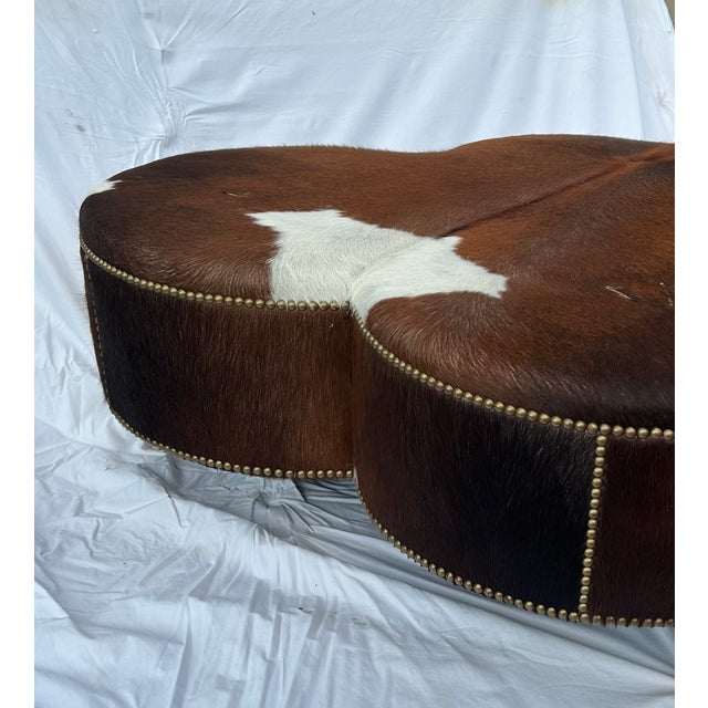 Description: This striking vintage cloverleaf-shaped ottoman is upholstered in genuine hair-on cowhide, showcasing a rich...