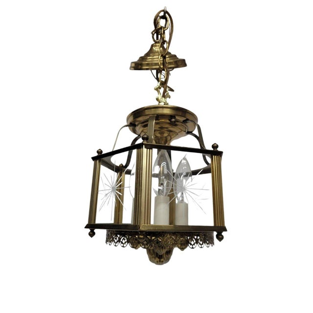 A warm, inviting glow meets timeless craftsmanship—this vintage brass lantern chandelier features etched starburst glass...