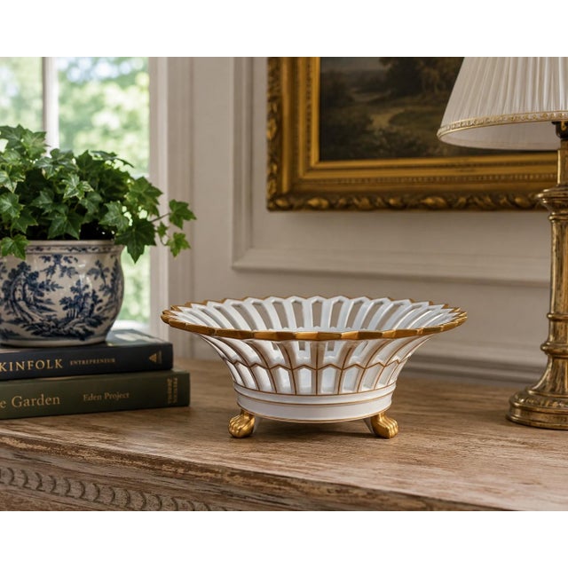 A refined reticulated porcelain basket, executed in a neoclassical idiom with delicate openwork and restrained gilt...
