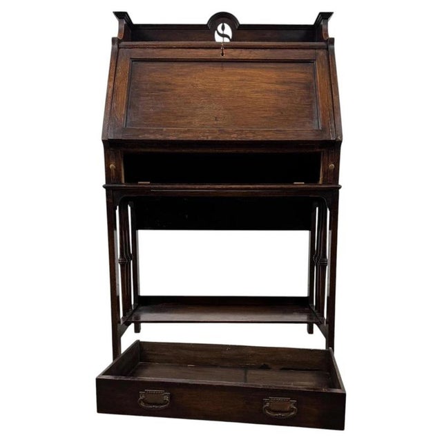 A charming early 20th-century English bureau, finely crafted from oak and distinguished by its unusual open fitted...