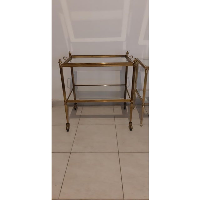 Two Maison LANCEL tables, gold-plated metal and glass, with mirrored surrounds, one on casters with a removable top, 59 cm...