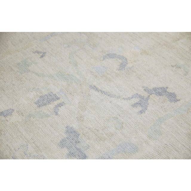 This modern Turkish Oushak rug is a stunning piece of art that has been handwoven using traditional techniques by skilled...