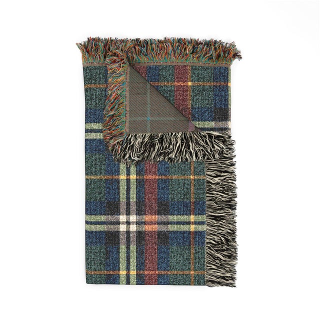 This tartan plaid woven throw blanket features forest green, navy blue, muted cranberry, cream, and golden ochre in a...