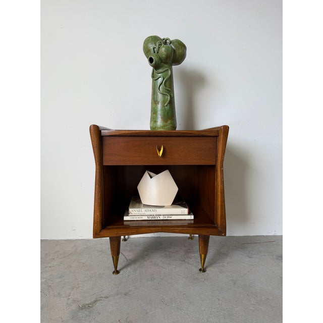 A beautifully designed mid-century modern nightstand from Kent Coffey’s “The Sharon” collection. Crafted in rich walnut,...
