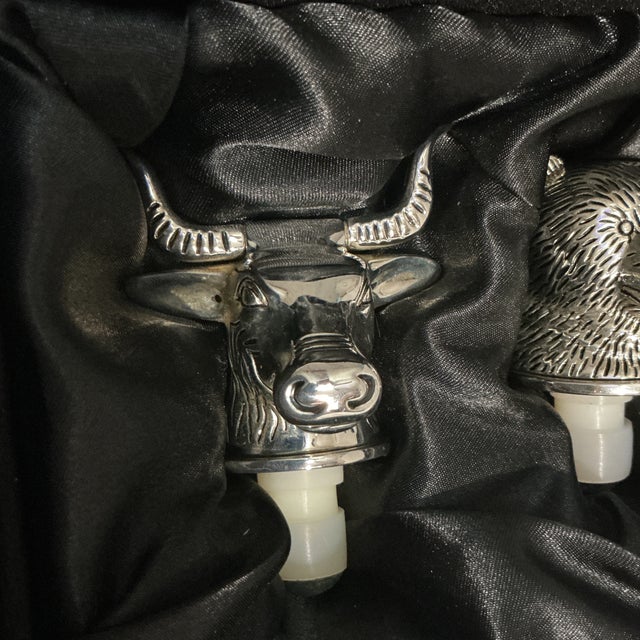 This product is a set of two vintage silver-plated wine bottle stoppers in the shape of a bull and bear, perfect for any...
