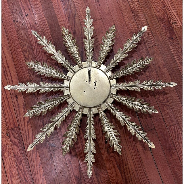 Eight Day Jeweled wind up sputnik clock with brass round face and cream/gold metal "rays." Spring operated. Size: 32" This...