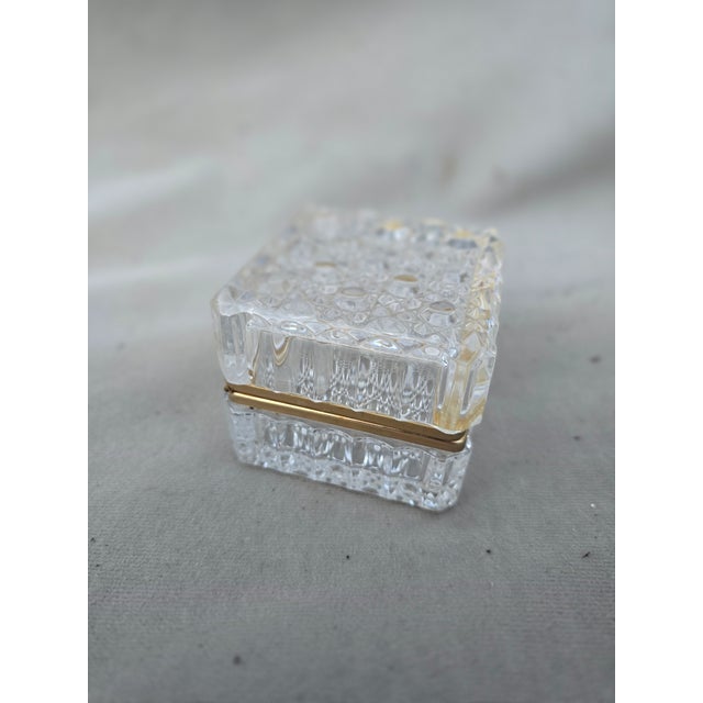 This is an exquisite square crystal box with brass accentsl. A small trinket holder that could be used almost anywhere in...
