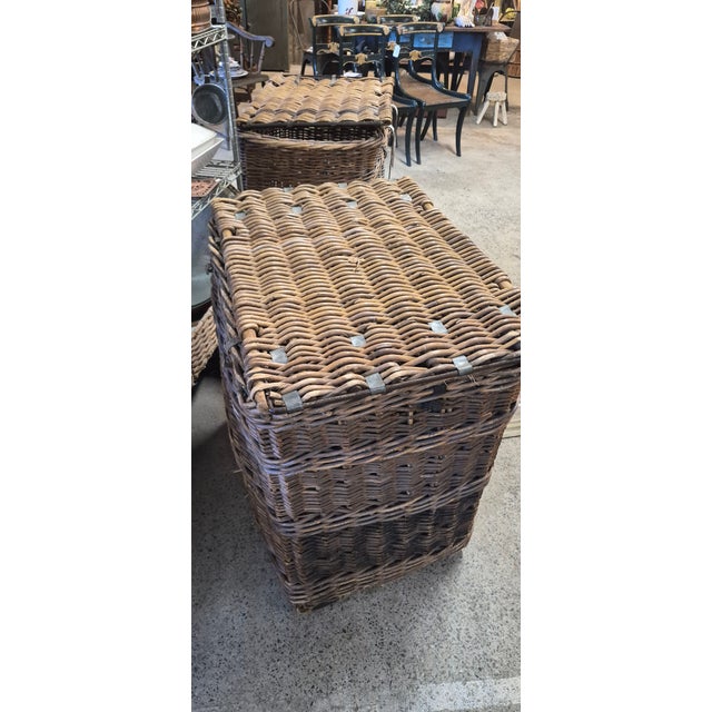 Large woven willow hamper with a hinged lid, metal reinforcement, fastening hardware, and painted ownership lettering....